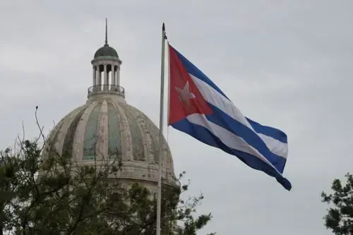 Havana's Capitolio with the Cuban flag waving in the background. 1