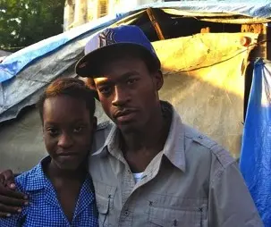 Cynthia Desert and her brother Ernso in the tent camp where they live in Port-at-Prince, Haiti. Behind them stands what remains of St. Anne's church after an earthquake struck the area two years ago. Image by Kem Knapp Sawyer. Haiti, 2012. Media file: Cynthia.jpg