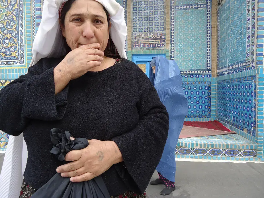 Makai stands in front of Mazar-e-Sharif's Blue Mosque. Behind her is her oldest daughter, Shirin. Image by Anna Badkhen. Afghanistan, 2012. Media file: DSC00071.JPG