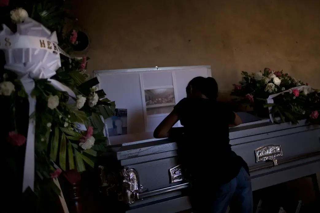 Nine-year-old Lisette leans over the coffin of her mother, Rosalia Esther Vazquez, at their home outside of Ciudad Juarez. The mother was killed in a massacre of factory workers commuting home from work. Gunmen entered the bus and fired randomly, killing five people and injuring more. Image by Dominic Bracco II. Mexico, 2011. Media file: Dominic_Bracco_II_023.jpg