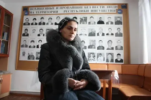 Dibikhan Pugoyeva, 39, in the office of the Mashr human rights group in Karabulak, Ingushetia, Russia.The board behind her shows pictures of people abducted in Ingushetia by security forces. Her son, Magomed Gorchkhanov, 17, was allegedly kidnapped in November 2010 and later found dead. Image: Tom Parfitt, Russia, February 2011.