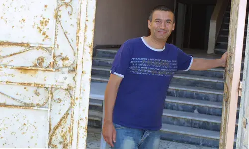 Real estate broker Essam Mortja in front of a Gaza home. Image by Reese Erlich. Gaza, 2011. image