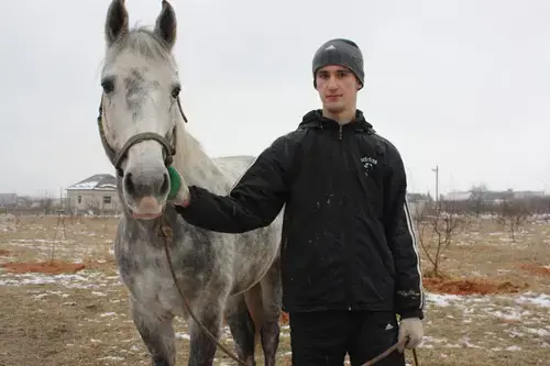 Ozdemir Tsipinov, 19, holds Makhosh, the horse thatbelonged to his father, Aslan Tsipinov, 51, who was murdered by Islamist gunmen on December 29, 2010, in Shalushka village, near Nalchik, in the Russian republic of Kabardino-Balkaria. Image by Tom Parfitt. Russia, February 2011.