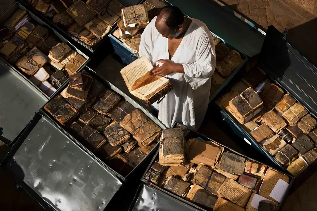 Ancient manuscripts from Mali, Niger, Ethiopia, Sudan and Nigeria line storage cases at Abdel Kader Haidara's home, the director of Bibliotheque Mama Haidara De Manuscripts, Timbuktu. These manuscripts are waiting their turn to be cataloged and added to the library collection. Inside them is a history of Africa from the 11th century onwards, with dialogue on Islam, trade, history, the law and so on. Image by Brent Stirton, National Geographic, September 2009.