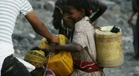 A girl carries jerry cans of water in Ethiopia. Image by Alex Stonehill. Ethiopia, 2008. A girl carries cans of water. Image by Alex Stonehill. Ethiopia, 2008.