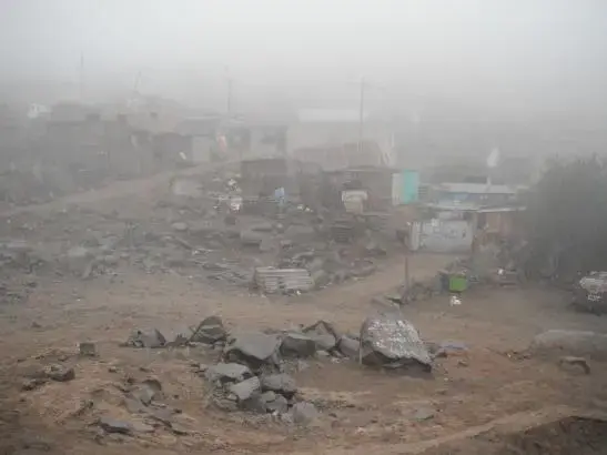 The view from the Santa Rosita Kindergarten, of the Lima shantytown of Huaycan, sprawling up the western slopes of the Andes. The sea mist sweeping in from the Pacific Ocean normally does not reach Huaycan. When it does, the temperature plummets and the humidity goes through the roof. It almost never rains here and there are plans afoot to extract water from the mist using giant nets. Image by Simeon Tegel. Peru, 2012. Media file: Waterless Lima 051.jpg