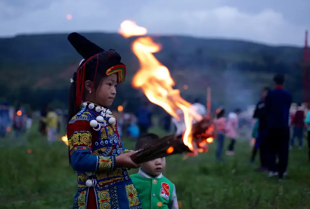 A Yi boy holds a flaming torch during Torch Festival celebrations in Liangshan prefecture, Sichuan province. Image by Max Duncan.  China, 2016.