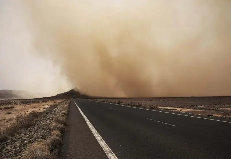 A sandstorm gusts, July 12, 2019, over a road about 50 kilometers (31 miles) from Djibouti, where African migrants walk en route to the shore and passage to Yemen with smugglers. Image by AP Photo / Nariman El-Mofty. Djibouti, 2019.
