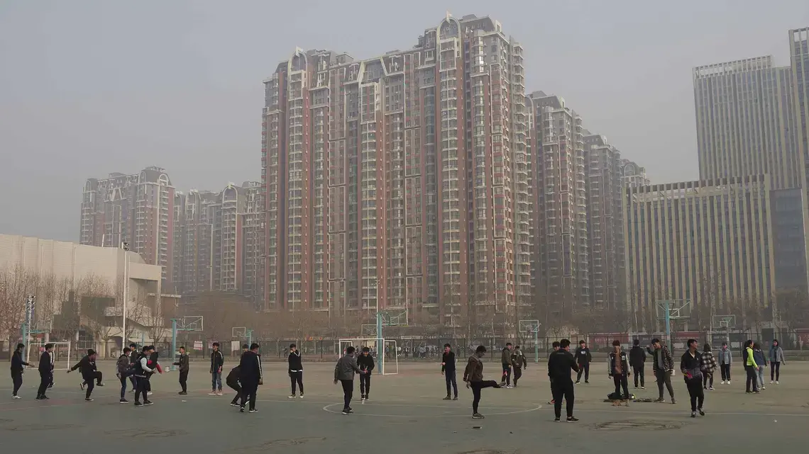 Students do morning exercises under polluted skies last spring at the Hebei Agricultural University in Shijiazhuang. Image by Larry C. Price. China, 2018.