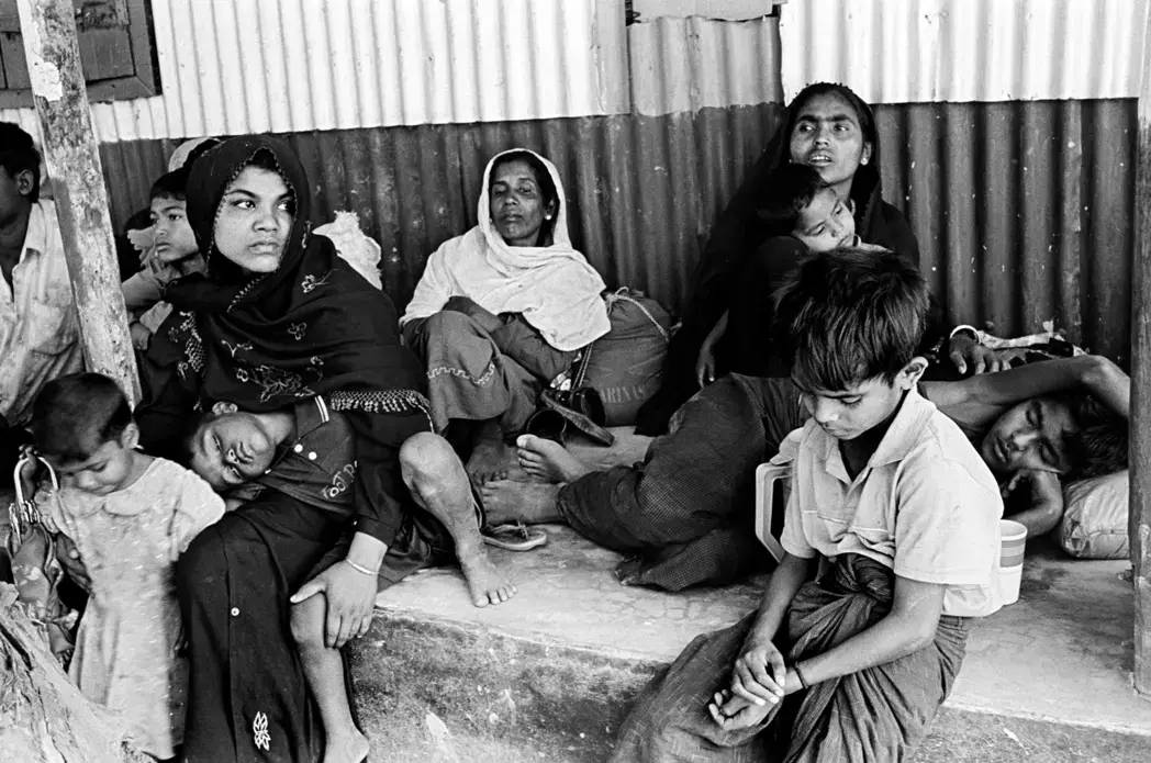 Exhausted from their journey out of Burma, 20 Rohingya were detained by Bangladeshi authorities as soon as their boat had crossed the Naf River from Burma and landed in the Shapuridip area of southern Bangladesh. Fifteen of the people in the group were women and children. Several of the children were sick. Border authorities pushed the entire group back to Burma the same night, but many in the group returned to Bangladesh the next day. Image by Greg Constantine. Bangladesh, 2012. Media file: bangladesh-rohingya.jpg