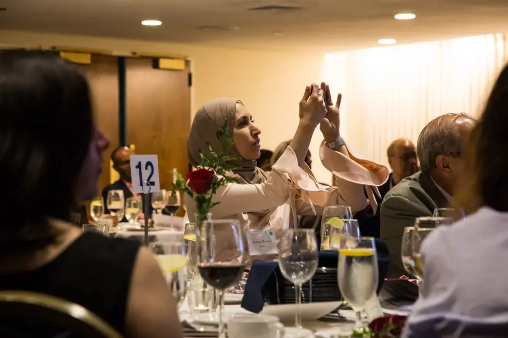 Sawsan Morrar, 2017 UC Berkeley Graduate School of Journalism fellow, photographs during the evening remarks. Image by Lorraine Ustaris. Washington, D.C., 2018.