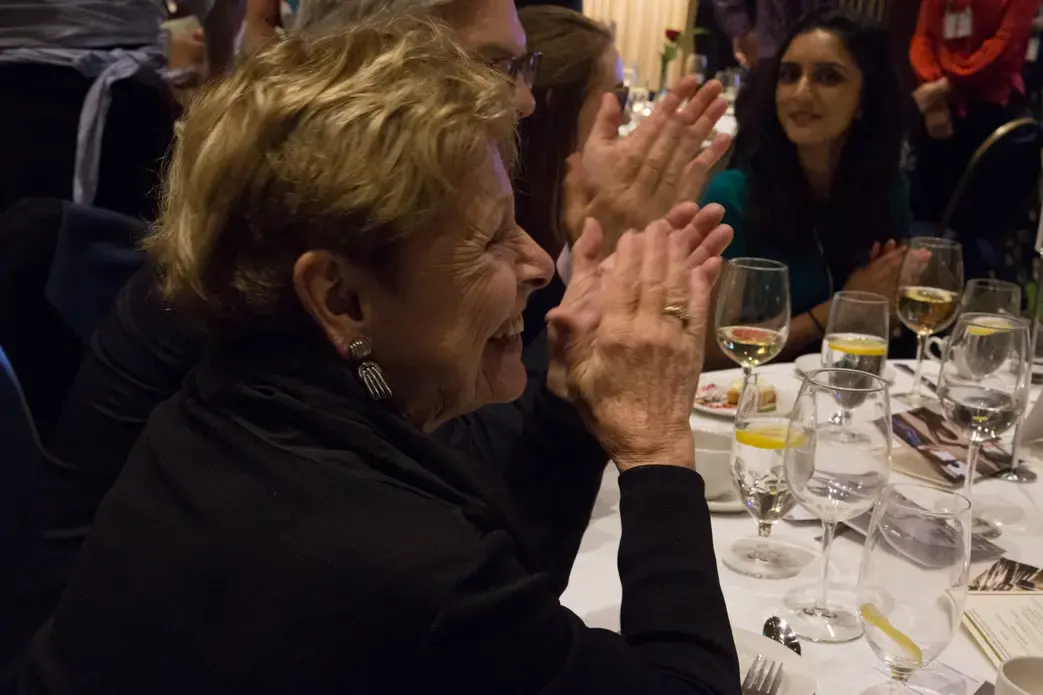 Pulitzer Center board member Linda Winslow applauds the special performance by Indigo Passariello. Image by Lorraine Ustaris. Washington, D.C., 2018.