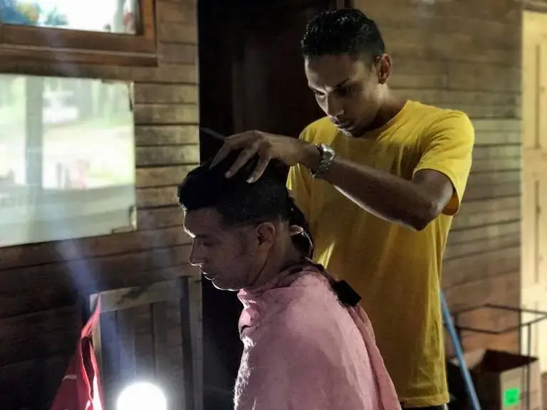 Lazaro Estrada gets a haircut at the camp for Cuban migrants in Gualaca. Image by Mario J. Pentón. Panama, 2017.