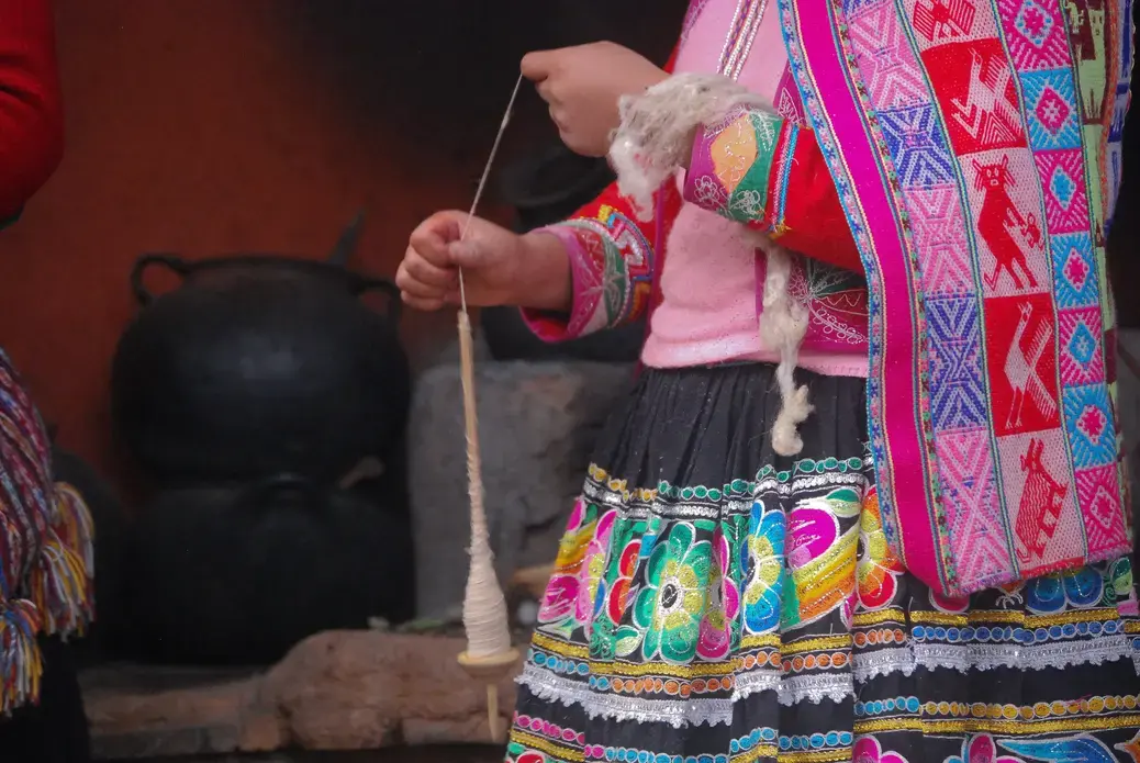 In Cuzco, Peru we went to a store that makes clothes, rugs/carpet, jewelry and they showed us how they make alpaca wool turn into this beautiful work of art filled with vibrant color and intricate patterns. This picture captures a woman making alpaca wool into string to prepare it to be dyed by using natural products. This was our first day in Peru where we were also really exposed to the culture and shown how this was also their lifestyle where they do this everyday for a living. Image by Cristin Pearson. Peru, 2018.<br />