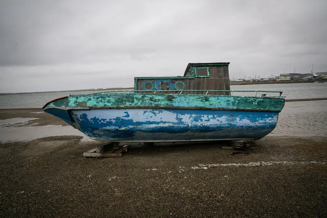 Isolated boat staying on the shore nearby Kaktovik. Image by Nick Mott. United States, 2019.