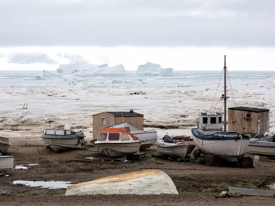 Boats and icebergs lie in Qaanaaq harbor. Vessels can only enter the harbor from late June or July until September; the sea is frozen for the rest of the year. Greenland, 2019. Image by Anna Filipova.