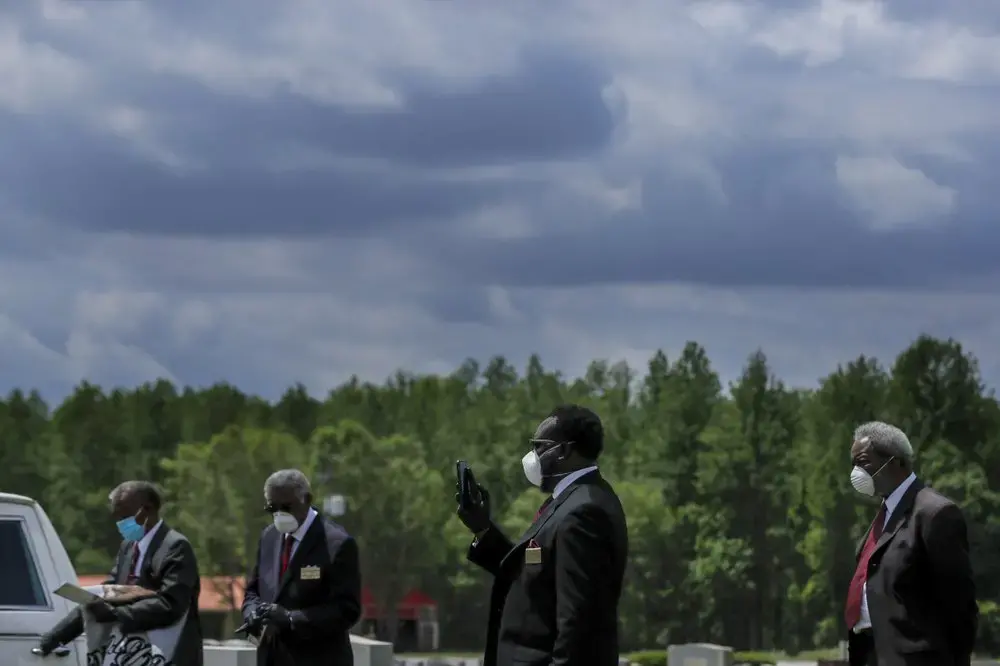 From left, Ronald Costello, Robert L. Albritten, Cordarial O. Holloway and Eddie Keith wait for the end of a funeral at Cedar Hill Cemetery on Saturday, April 18, 2020, in Dawson, Ga. Image by Brynn Anderson / AP Photo. United States, 2020.
