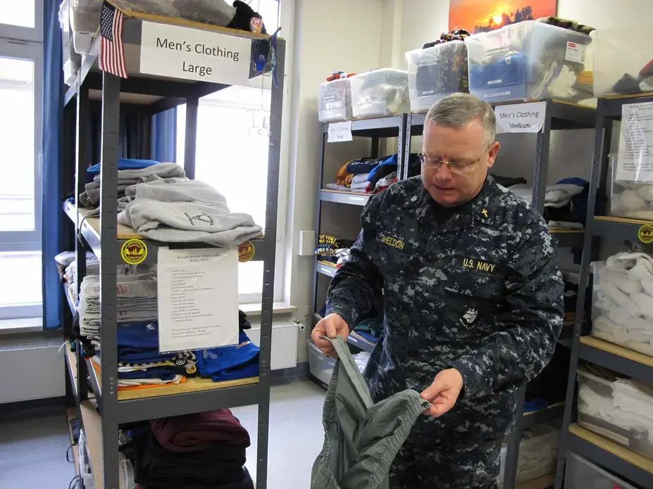 Cmdr. Joseph Sheldon, a Navy chaplain, examines a pair of pants that have been taken apart and installed with Velcro so a wounded soldier can dress themselves. Image by Meg Jones. Germany, 2011. Cmdr. Joseph Sheldon, a Navy chaplain, examines a pair of pants that have been taken apart and installed with Velcro so a wounded soldier can dress themselves. Image by Meg Jones. Germany, 2011.
