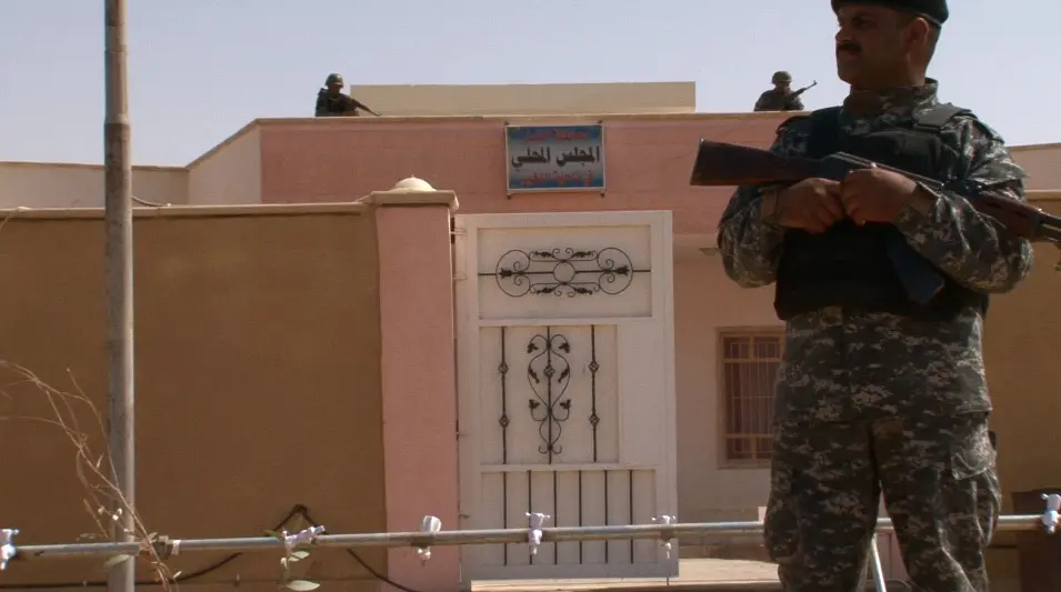 Soldiers stand guard in front of a municipal building in Nakhib, Iraq. Image by David Enders. Iraq, 2011. Media file: iraqenders.jpg
