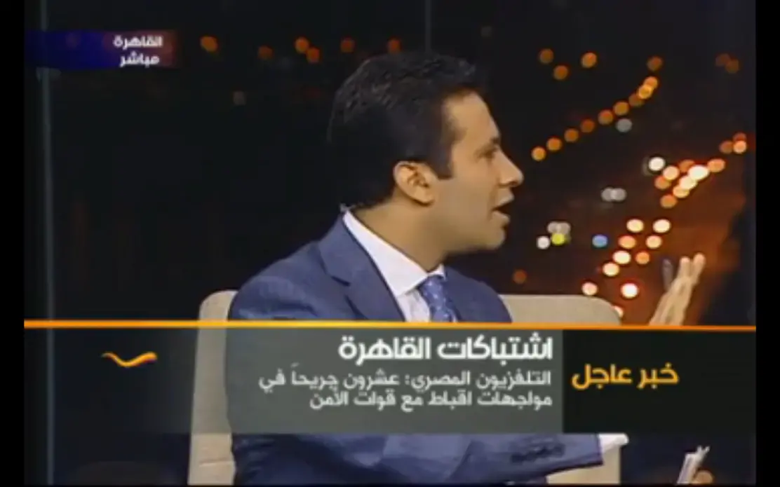 The anchor of the U.S.-funded TV station Al-Hurra speaking to armed security forces who raided the studio on October 9 as he was on air reporting on the clashes. Egypt, 2011. Media file: ishtbakaat.jpg