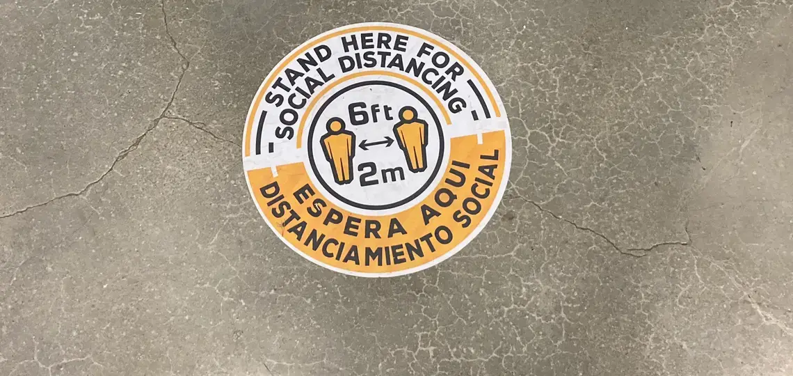 A floor sticker reminds people to maintain physical distance at MICOP's office. Image by Julia Knoerr. United States, 2020.