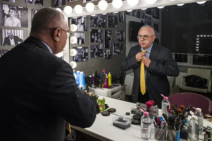 Pavel Lobkov adjusting his tie in front of a mirror. Image by Misha Friedman. Russia, 2018.