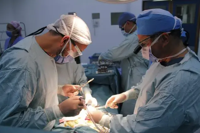 Surgeons Pedro Rivas (left) and Carlos Rodríguez (right) in the midst of a kidney transplant at the private hospital Clínica Metropolitana. Image by Flaviana Sandoval. Venezuela, 2018.