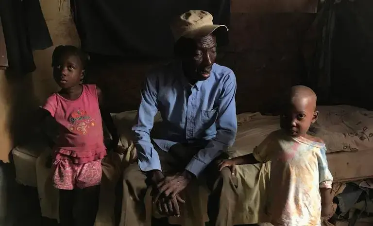 Telfort Innocent (center) with two of his 14 children inside his family’s shack at the Teren Toto camp. The camp is one of 22 official camps that still exist in Haiti 10 years after the Jan. 12, 2010, earthquake. Image by Jose A. Iglesias. Haiti, 2019.