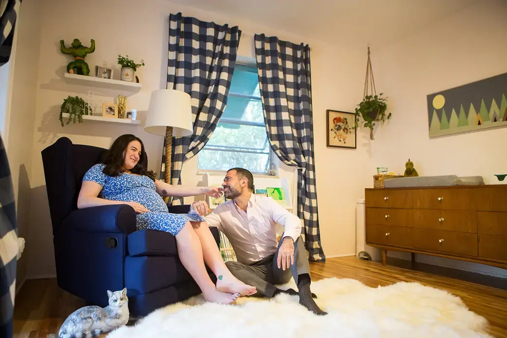 Sloane Borr, at nine months pregnant, sits with her husband, Paul, in their baby's room. Image by Roy Llera. United States, 2017.