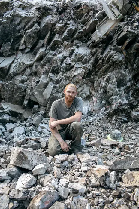 A worker on the road building team pauses in the rubble at McKenzie Inlet. Image by Joshua Cogan. United States, 2019.