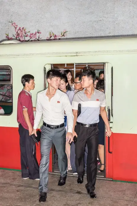 Commuters on the Pyongyang Metro. The capital, marooned by politics, presents a panorama from another time. Image by Max Pinckers/The New Yorker. North Korea, 2017.