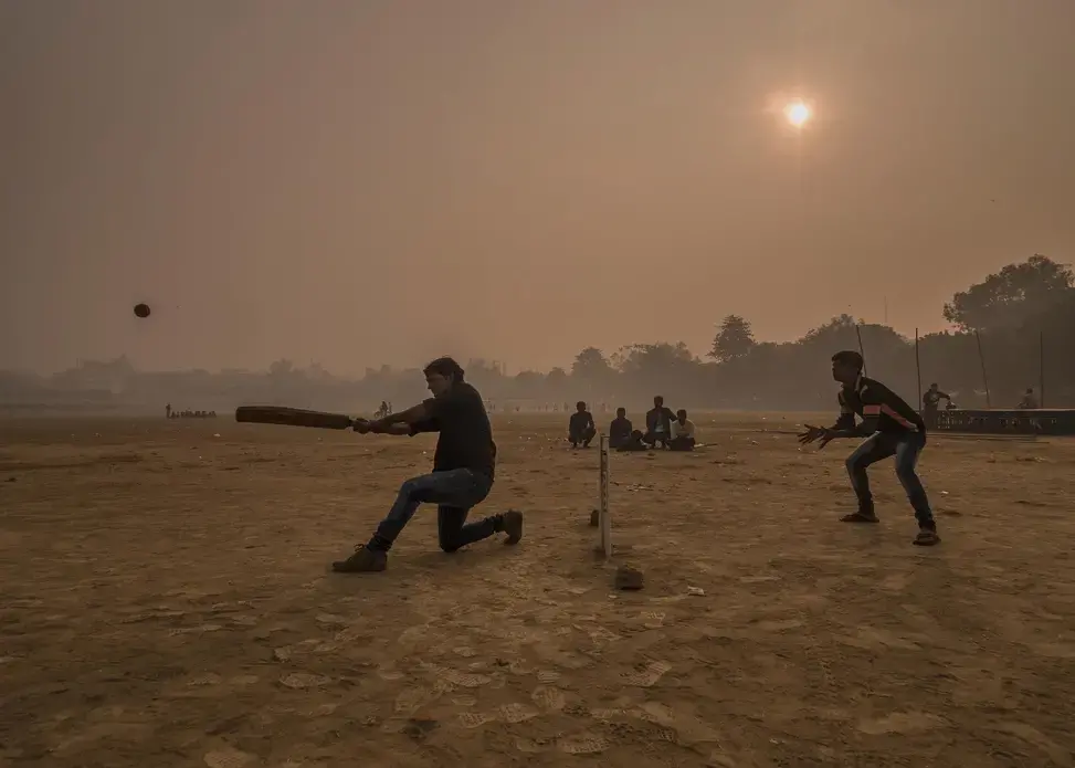 Surrounded by a thick layer of pollution that settled over Patna overnight, a dawn cricket match gets underway at Gandhi Maidan Park in central Patna. Image by Larry C. Price. India, 2018.
