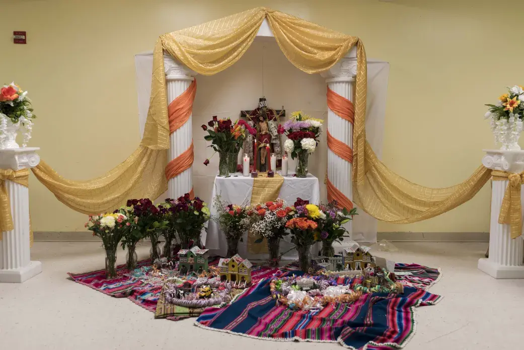 The altar of Santa Vera Cruz in Arlington, Virginia, 2016. Santa Vera Cruz is the beginning of the agricultural new year on May 3rd, after Carnival, and the period of fertility. During Santa Vera Cruz, people give thanks for what they received in the previous year, and ask for another good year, leaving objects representing their desires at the altar. Later, people sing to Santa Vera Cruz with their comparsas. Image by Carey Averbook. United States, 2017.