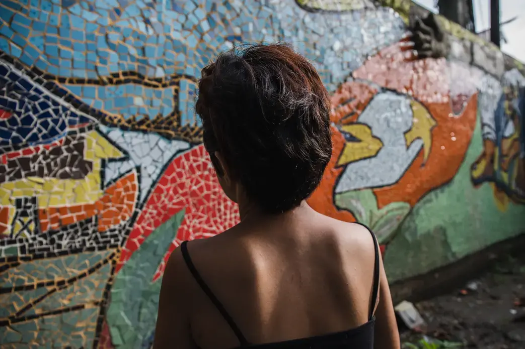Sara in front of a mosaic she helped make with other survivors and members of Rise Up. Image by Pat Nabong. Philippines, 2017.
