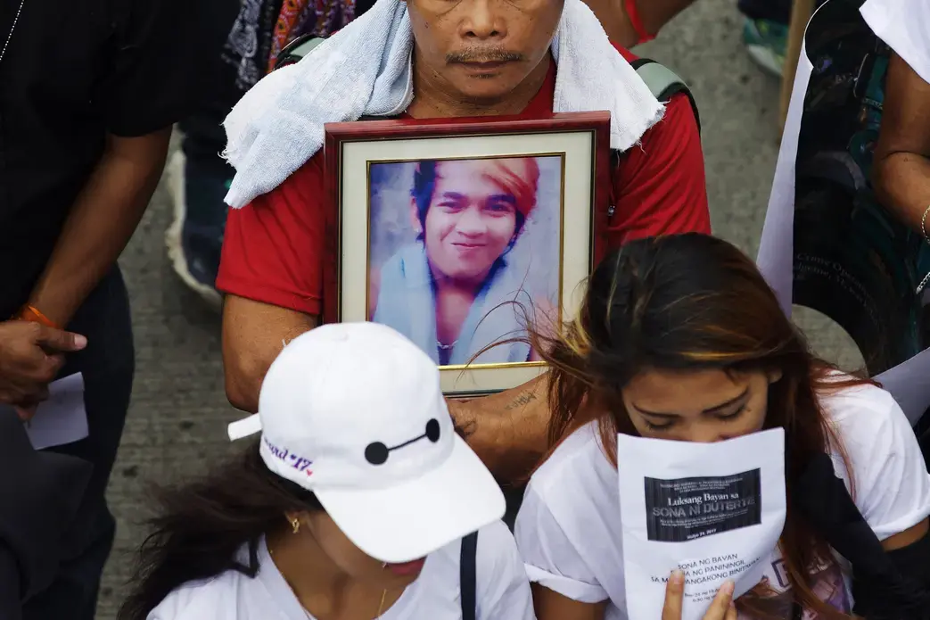 A father of a slain drug suspect clutches a photograph of his late son at a rally in Quezon City, on July 24, 2017. Image by Pat Nabong. Philippines, 2017.