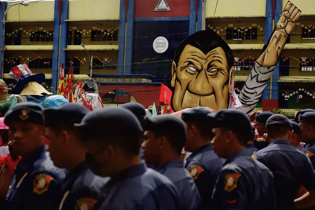 Law enforcement officers in front of an effigy of President Rodrigo Duterte during a rally against the extrajudicial killings and other issues in Quezon City, July 24, 2017. Image by Pat Nabong. Philippines, 2017.