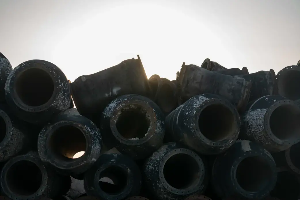 A heap of pipes probably used for dredging sand lie on a parcel of reclaimed land at the planned site of a new airport in the southern city of Xiamen. | The prosperous southern coastal city of Xiamen started in 2016 to reclaim land in preparation to build a controversial second airport on Dadeng Island, a 13 square kilometer island on the border of Xiamen and Kinmen island which belongs to Taiwan.When the airport is completed on reclaimed land, the size of Dadeng island will have doubled.The plans are that by 2025, the airport will have two runways, and be able to serve 45 million passengers per year. Right now, highways and subways connecting Xiamen and Dadeng Island are under construction. Although it’s widely reported that the airport is scheduled to be operational by 2020, there is at present no evidence that the central government and the military have given the final approval to the construction of the airport. Image by Sim Chi Yin. China, 2018.