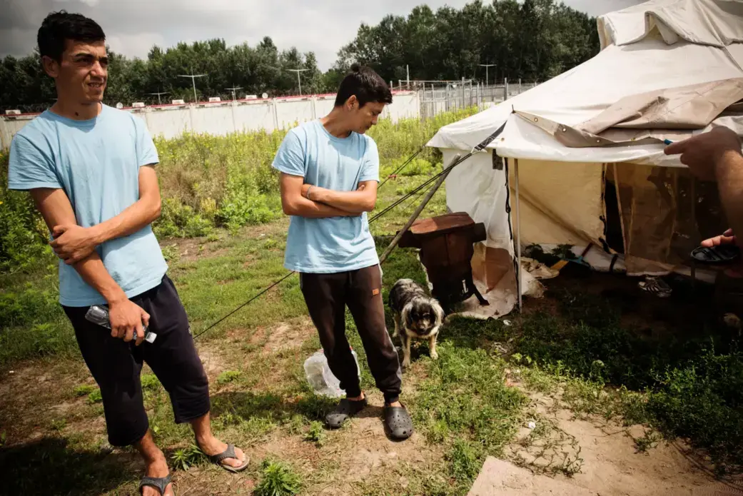 Hashmat (L) and Faiz outside their living quarters in June. Image by Zack Beauchamp for Vox. Hungary, 2018. Hashmat (L) and Faiz outside their living quarters in June. Image by Zack Beauchamp for Vox. Hungary, 2018.
