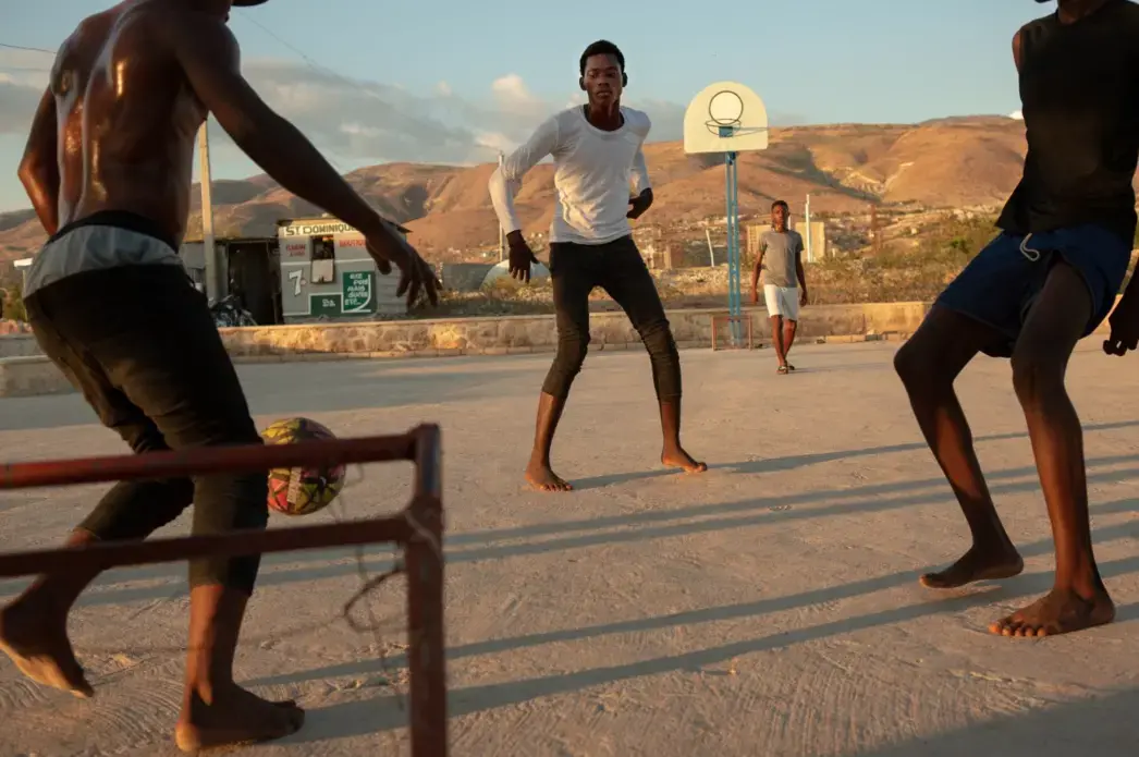 Young men play soccer in the recently completed public plaza in Canaan 1, a neighborhood of greater Canaan. Since the city’s inception as a haven for people who were displaced by Haiti’s 2010 earthquake, its residents have been largely left to themselves. Image by Allison Shelley. Haiti, 2019.