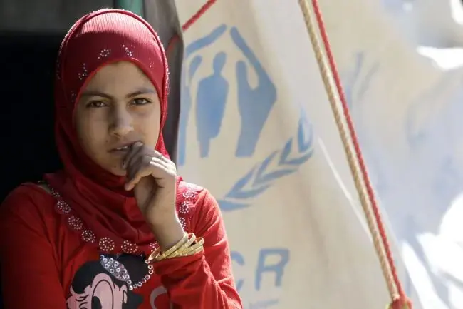 A Syrian refugee girl, who fled the violence in her country, stands outside a refugee camp close to the Syrian border, on July 17, 2012. According to the UNHCR, the number of refugees has tripled since April, reaching 110,000 at camps in Turkey, Lebanon, Iraq and Jordan. (Khalil Mazraawi/AFP/Getty Images) Media file: syria_refugee_crisis_tide-1.jpg