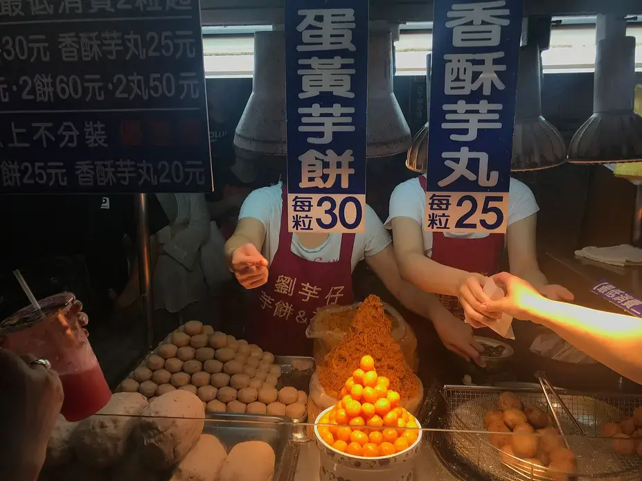 This stall sells taro fritters. In front is a pyramid of egg yolks used in the fritters. Image by Melissa McCart. Taiwan, 2018. 