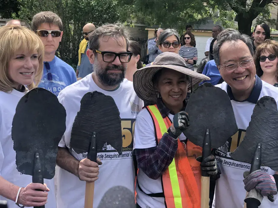 Artist Pedro Reyes and cellist Yo-Yo Ma prepare to plant trees with community members at North Lawndale's 150-year anniversary celebration, presenting Reyes' 2017 work "Palas por pistolas." Image by Terrance Patterson. United States, 2019. Artist Pedro Reyes and cellist Yo-Yo Ma prepare to plant trees with community members at North Lawndale's 150-year anniversary celebration, presenting Reyes' 2017 work "Palas por pistolas" (Guns into Shovels). Image by Terrance Patterson. United States, 2019.