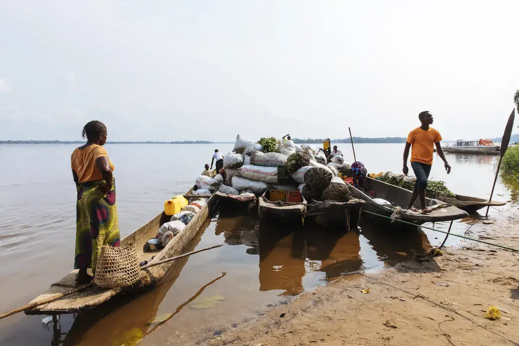 Traders load motorized canoes with goods to be transported to Kisangani, an eight-hour trip. Image by Sarah Waiswa. Democratic Republic of Congo, 2019.
