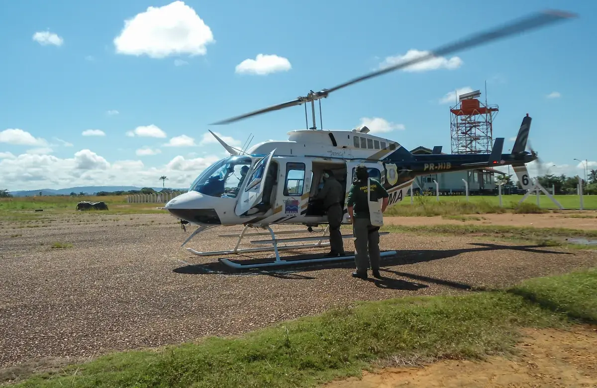 A person stands next to a helicopter. 