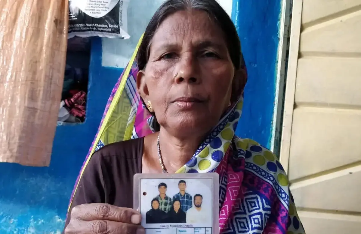 A woman holds her family's ID card in India