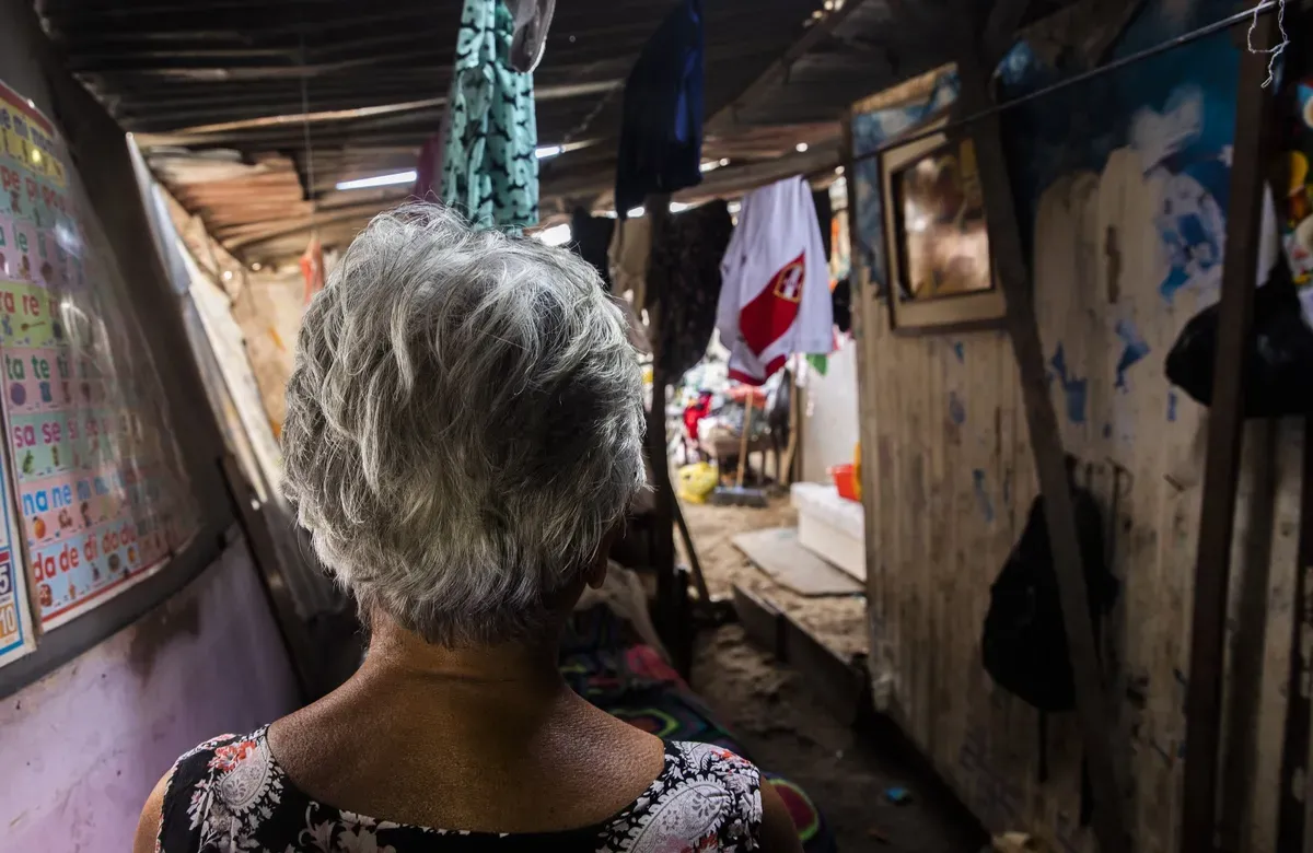a woman faces away from the camera inside of a dilapidated home