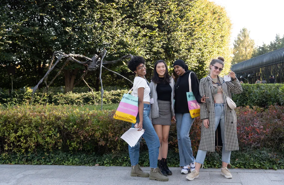 Students pose outside with Pulitzer Center tote bags