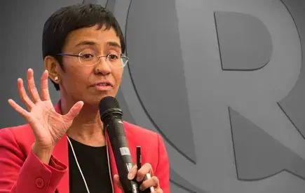 Maria Ressa speaks into a microphone