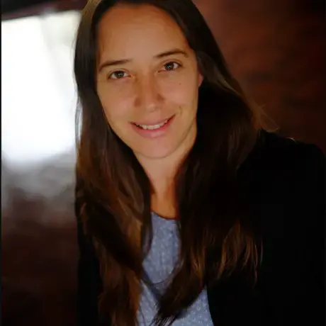 Screen Shot 2021-11-22 at 10.31.15 PM.png A woman wears a black jacket and blue blouse.