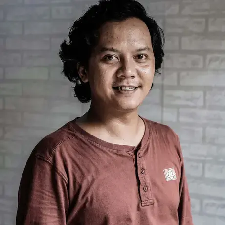 A person wears a red long-sleeve shirt with buttons.